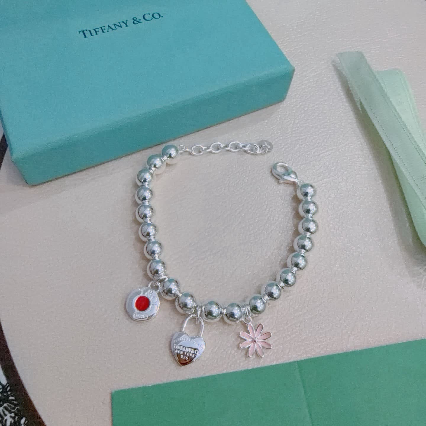 Tiffany & Co. Sterling Silver Bead Bracelet with Lock and Flower Charms